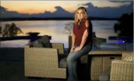  ?? MARK HUMPHREY — THE ASSOCIATED PRESS ?? Heather Melton sits on a patio at her home in Big Sandy, Tenn., as the sun sets over the Big Sandy River. Heather and her husband, Sonny Melton, were in the final stages of building the home when Sonny died when he was shot while protecting Heather at the Route 91 Harvest Festival mass shooting in Las Vegas. Now a year later, many survivors, who were already bonded through the music, have formed a tight-knit, encouragin­g community as they heal, support and remember. They call themselves “Country Strong.”