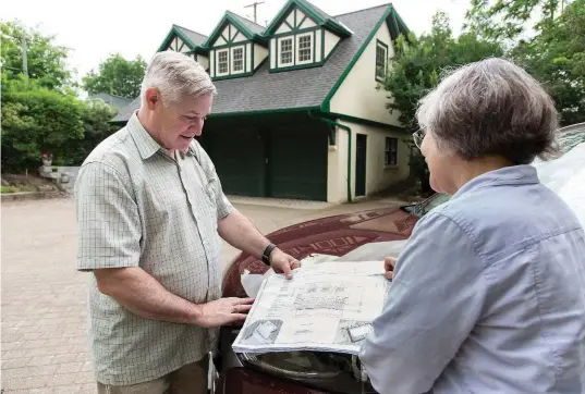  ??  ?? Jennifer Stacey looks over the drawings for the music studio, which is in the upper level of the garage in the background, with architect, friend and fellow musician Stephen King.