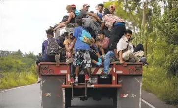  ?? A FREIGHT TRUCK Moises Castillo Associated Press ?? slowed to let travelers climb on the back Friday in Rio Dulce, Guatemala. Some 3,000 to 4,000 Hondurans were estimated to have entered Guatemala the previous day, heading toward Mexico.