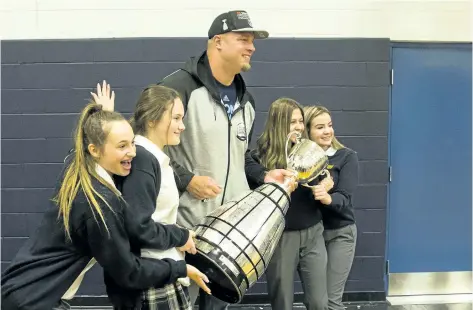  ?? JULIE JOCSAK/ STANDARD STAFF ?? Toronto Argonaut and Fonthill native Chris Van Zeyl brings the Grey Cup to his old high school, Notre Dame College School in Welland, where students were able to have their photo taken with him and the Cup on Tuesday.