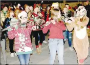  ?? (File photo/NWA Democrat-Gazette/Lynn Kutter) ?? The Farmington High School band dressed for the occasion and provided a lively soundtrack during the 2019 Farmington Christmas Parade. This year, the parade will start at Farmington Sports Complex on Southwinds and go in front of the Farmington Public Library on Cimarron Place, across from the Post Office. The parade will not be on U.S. 62.