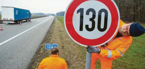 ?? Foto: Jens Büttner, dpa ?? Ein Straßenwär­ter montiert ein Tempolimit-Schild: In Franken und Schwaben wird so schnell gerast wie nirgends sonst auf deutschen Autobahnen.