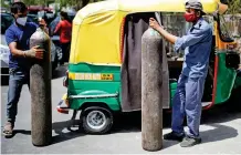  ??  ?? Oxygen crisis: Rickshaw drivers at refilling station