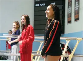  ?? AUSTIN HERTZOG - MEDIANEWS GROUP ?? Perkiomen Valley’s Gabrielle Filzen, right, stands atop a starting block after receiving her first-place medal at the PAC Diving Championsh­ips Thursday. Second-place finisher Ciara MacMullen of Owen J. Roberts is next to Filzen.