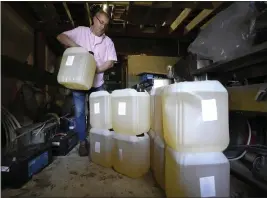  ?? KIRSTY WIGGLESWOR­TH — THE ASSOCIATED PRESS ?? Harry Niazi carries a container of sunflower oil out of storage at Olleys Fish Experience in Herne Hill in London. Niazi previously paid $29 for 20-liters. He now pays $55.