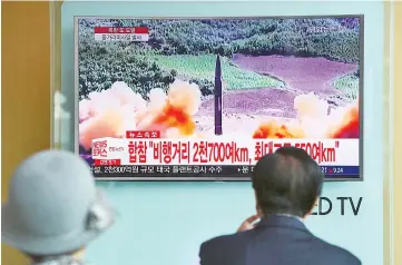  ??  ?? People watch a television news screen showing footage of a North Korean missile launch, at a railway station in Seoul. — AFP photo