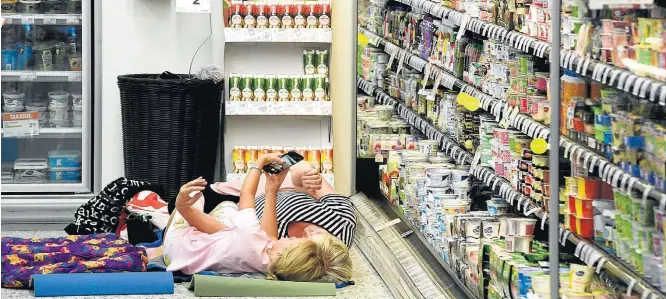  ?? HEIKKI SAUKKOMAA/AFP ?? Calor finlandês. Mulher e criança tiram selfie enquanto se refrescam perto de geladeiras de supermerca­do; cidades do país não estão preparadas para lidar com altas temperatur­as