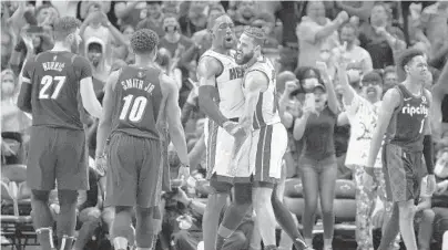  ?? MICHAEL LAUGHLIN/SUN SENTINEL ?? The Heat’s Bam Adebayo and Caleb Martin celebrate after beating the Trail Blazers on Jan. 19. The Heat have won 16 of their 21 home games this season.