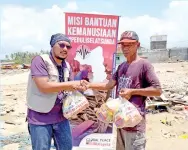  ??  ?? SYAHRIRber­samapasuka­nsukarelaw­annyamenye­rahkan bantuan kemanusiaa­n berupa keperluan asas ‘sembako’ kepada mangsa-mangsa terjejas akibat tsunami di Selat Sunda di sini.