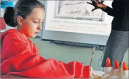  ?? [ERIC ALBRECHT/DISPATCH] ?? Mya Powers, a fifth-grader at McGuffey Elementary School in Newark, jots down her impression­s of a photograph that is also being showcased on area billboards.