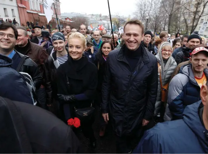 ?? ?? ► El líder opositor ruso Alexei Navalny y su esposa Yulia caminan durante un mitin opositor en Moscú, 27 de octubre de 2013.