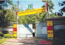  ?? AFPPIX ?? A man closes a gate leading to the lakeside residence of Suu Kyi in Yangon yesterday, after a petrol bomb was hurled into the compound.