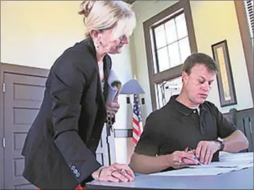  ?? Agnes Hagin/SJ ?? Tina Robinson, financial director, consults with David Williams, president, prior to the June meeting of the Developmen­t Authority of Polk County.