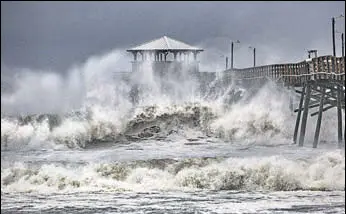  ?? AP ?? Waves slam a pier at Atlantic Beach, North Carolina, on Thursday.