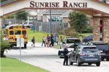  ?? Jason Fochtman / Staff photograph­er ?? Children exit a school bus as deputies with the Montgomery County Sheriff ’s Office investigat­e a shooting incident in the 18400 block of Sunrise Pines in the Sunrise Ranch subdivisio­n.