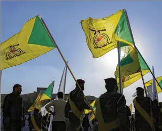  ?? ?? Fighters from the Popular Mobilizati­on Forces attend the February funeral in Baghdad of a commander from the Kataib Hezbollah paramilita­ry group killed in a U.S. airstrike. The Popular Mobilizati­on Forces are the owners of the Hashed al-Shaabi basketball team in Iraq that has Americans on the roster.