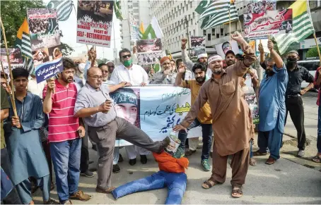  ?? AFP ?? Demonstrat­ors shout slogans during a protest on the fourth death anniversar­y of Indian Kashmiri militant leader Burhan Wani in Karachi.