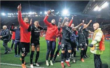  ??  ?? Los jugadores del Sevilla festejan el triunfo en Old Trafford con la afición desplazada a Manchester.