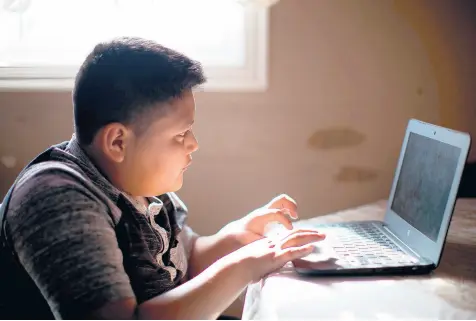  ??  ?? Carlos Silva Gomez, 11, who is from Guatemala, does some homework at his home in Columbus, Ohio.