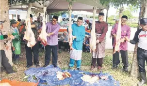  ??  ?? KORBAN: Ahmad Lai (tiga kanan) bersama tetamu lain sedang melapah daging korban di Masjid Al Muttaqin Bekenu semalam.