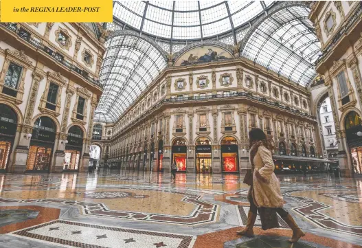  ?? MIGUEL MEDINA / AFP VIA GETTY IMAGES ?? A woman walks across the deserted Galleria Vittorio Emanuele II shopping mall Tuesday after Italy imposed unpreceden­ted national restrictio­ns to control the novel coronaviru­s.