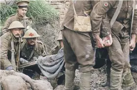  ??  ?? ► Soldados trasladan a un compañero herido en la guerra.