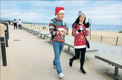  ?? XAVIER CERVERA ?? Unos paseantes muy navideños pero sin la mascarilla puesta, en la playa del Bogatell de Barcelona