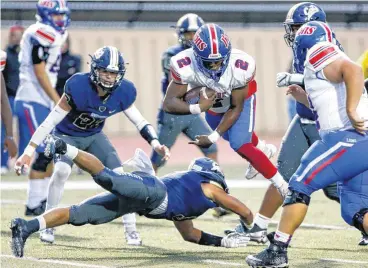  ??  ?? Moore’s Daniel Hishaw Jr. (2) leaps over Southmoore’s Elijah Brewer (5) for a touchdown during Friday’s high school football game at Moore Schools Stadium in Moore.