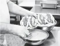  ??  ?? Seferobic prepares orders at Lafayette Coney Island in Detroit.