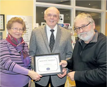  ?? JEN HARDY/SPECIAL TO POSTMEDIA NETWORK ?? Cathy and John Henderson receive a certificat­e for their outstandin­g efforts in preserving Thorold’s heritage from Heritage Thorold committee chair Craig Finlay, at right.