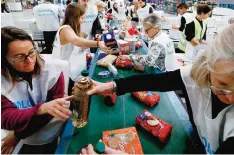  ??  ?? BARCELONA: ‘El Banc dels Aliments’ (Food Bank Foundation) volunteers classify food to be distribute­d among the poor, at a warehouse in Barcelona during a national charity campaign to fight hunger. —AFP