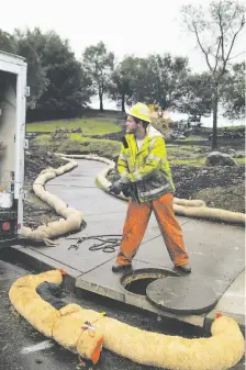  ?? Gabrielle Lurie / The Chronicle ?? Ivan Iverson pulls the line on a machine that cleans out debris from a manhole in the Fountaingr­ove area of Santa Rosa, to make sure toxic waste doesn’t get into nearby creeks and rivers.