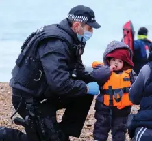  ?? ?? Safe in Kent: Young migrant with British policeman