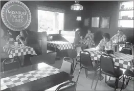  ?? SUSAN HOLLAND/WESTSIDE EAGLE OBSERVER ?? Hungry diners enjoy their evening meal at the Gravette location of The Station Cafe. Customers are able to choose from a wide variety of steakburge­rs, sandwiches, salads, soup and chili, dinners and desserts. Breakfast is served all day in the dining room decorated with railroad signs, locomotive prints and other railroad memorabili­a.