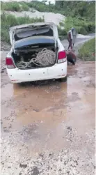  ?? ?? A motor vehicle stuck in mud on the St Toolies Road in Manchester on Monday