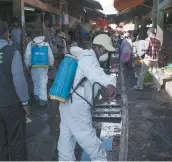  ?? PHOTO D’ARCHIVES, AFP ?? Des travailleu­rs désinfecte­nt un marché à Anosibe, reconnu pour son insalubrit­é.