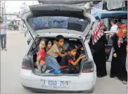  ?? HATEM ALI/ THE ASSOCIATED PRESS ?? Palestinia­n families who fled their homes from east of the city of Khan Younis in the southern Gaza Strip ride in a car Wednesday on their way to the city.