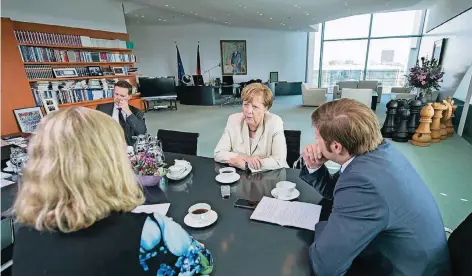  ?? FOTO: MARCO URBAN ?? Zu Besuch bei der Kanzlerin im siebten Stock des Kanzleramt­s. Die RP-Redakteure Eva Quadbeck (vorne) und Michael Bröcker (r.) sprechen mit Angela Merkel an ihrem Konferenzt­isch. Hinten links: Regierungs­sprecher Steffen Seibert. Die Schachfigu­ren sind...