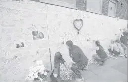  ??  ?? People write in a wall as a tribute to Grenfell Tower’s residents at Latymer community centre in London on Thursday.