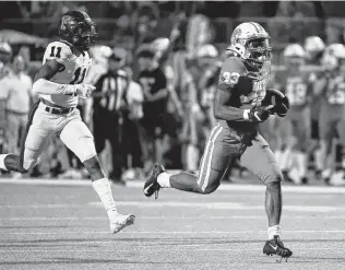  ?? Eric Christian Smith / Contributo­r ?? Katy’s Seth Davis, right, runs past Samuel Kale of Tompkins for a touchdown during the second half of Friday night’s game at Legacy Stadium in Katy.