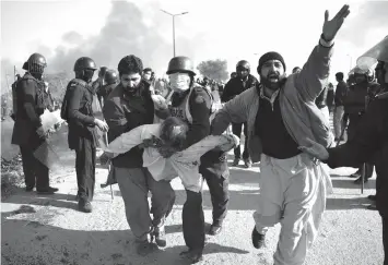  ?? AGENCE FRANCE PRESSE ?? An injured activist from the Tehreek-i-Labaik Yah Rasool Allah Pakistan (TLYRAP) religious group is carried away from clashes with police in Islamabad.