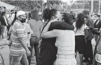  ?? Angel DeJesus / Associated Press ?? Women embrace while waiting for details about their relatives who are inmates at Litoral Penitentia­ry in Guayaquil, Ecuador.