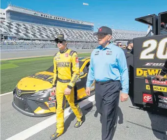  ??  ?? Driver Erik Jones walks with team owner, Joe Gibbs during qualifying for the NASCAR Cup Series Daytona 500 at Daytona Internatio­nal Speedway on Sunday.