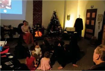  ??  ?? Youngsters gather in front of the fireplace to listen to stories of Christmas Long Ago.