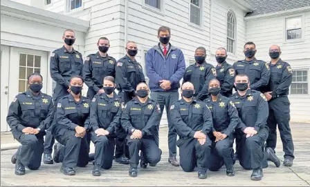  ?? COURTESY WORCESTER COUNTY SHERIFF'S OFFICE ?? Worcester County Sheriff Lew Evangelidi­s, center, is pictured with the recruits of Basic Recruit Training Academy #54, who graduated in a small, private ceremony held on the grounds of the Sheriff's Office. The ceremony had to forgo all previous graduation traditions held at the office due to COVID-19 precaution­s.