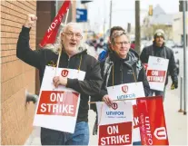  ?? MATT SMITH ?? Unifor members Dan Blum and Al Mazurek walk the picket line outside wwof the Sasktel building downtown on Friday.