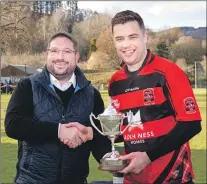  ??  ?? Glenurquha­rt captain Michael Fraser receives the MacDonald Cup from Garry Mackintosh.