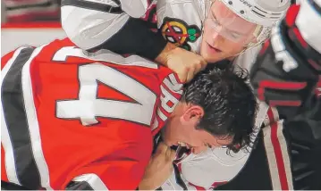  ?? | PAUL BERESWILL/GETTY IMAGES ?? Hawks captain Jonathan Toews tangles with the Devils’ Adam Henrique last month.
