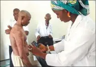  ?? SEBASTIEN RIEUSSEC / AGENCE FRANCE-PRESSE ?? A doctor in a health center in Koulikoro takes pictures of a patient suffering from a skin disease. An online dermatolog­y platform offers a diagnostic and instructio­ns for a treatment from a doctor located in Bamako, Mali.