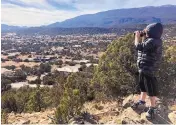  ?? COURTESY OF AMY OWEN ?? Teddy Owen takes in the view of the Rincon Loop neighborho­od from a ridge above the small community in the East Mountains. Albuquerqu­e Public Schools plans to build a depot for as many as 50 buses just to the left of his view.